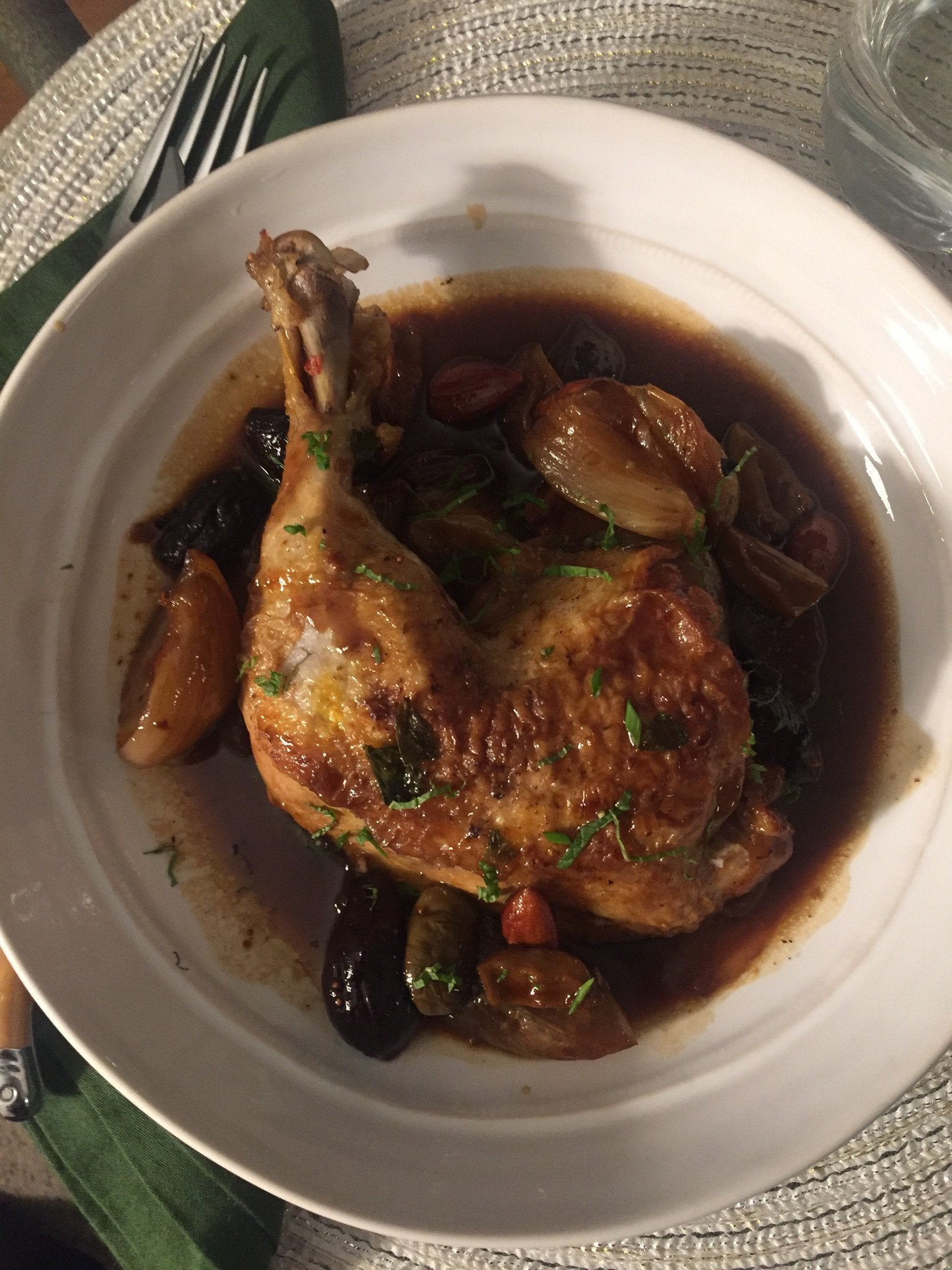 bone-in chicken thigh on a white shallow bowl with fig and orange sauce