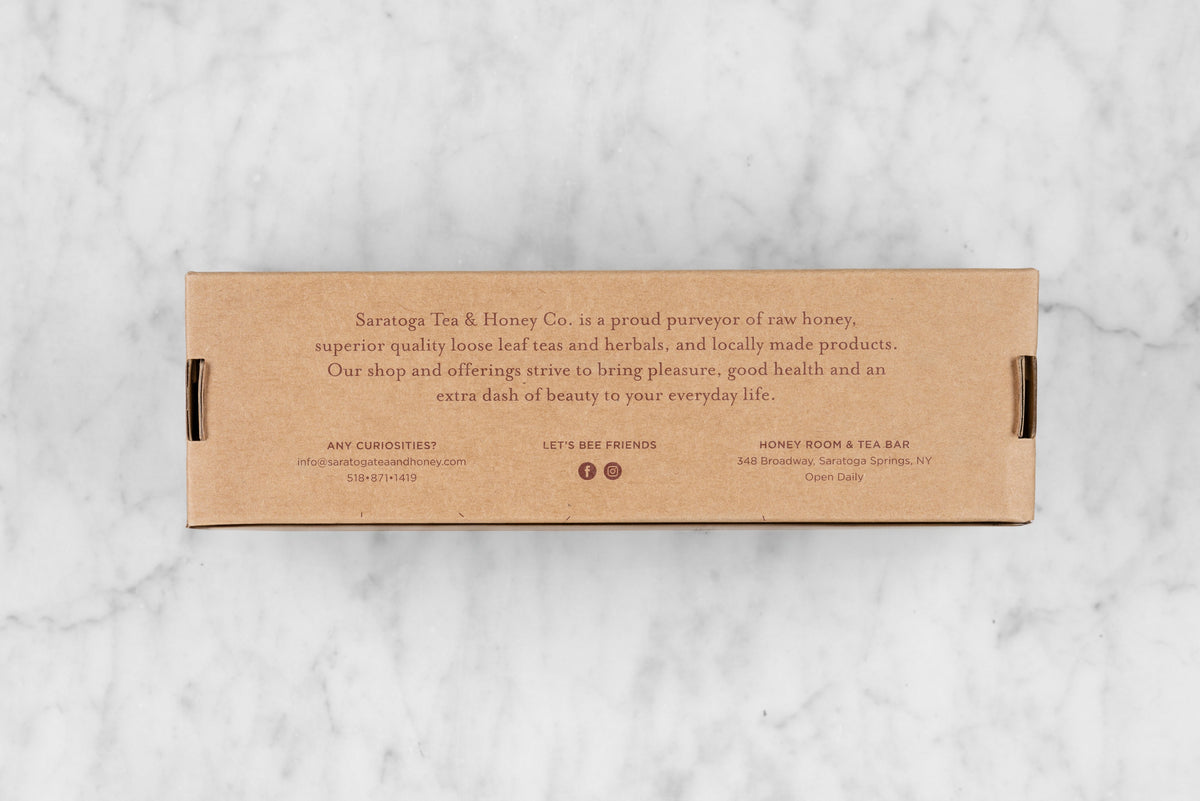 Back of honey gift set kraft box reading: Saratoga Tea & Honey Co. is a proud purveyor of raw honey, superior quality loose leaf teas and herbals, and locally made products. Our shop and offering strive to bring pleasure, good health, and an extra dash of beauty to your everyday life.