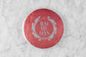 2012 Bai Mu Dan large, round tea cake wrapped in paper with the words "Bai Mu Dan 2012".