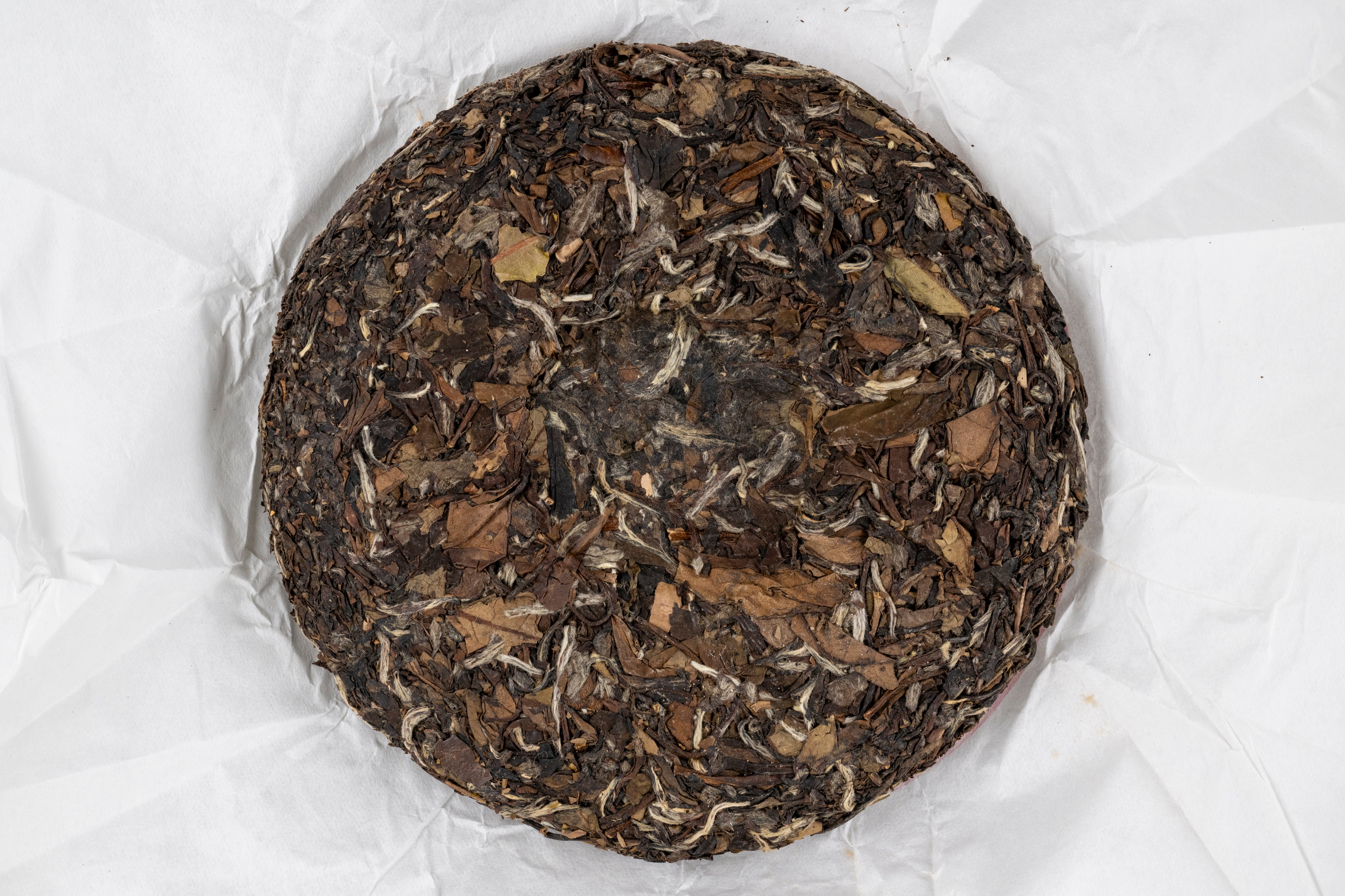 unwrapped cake of 2012 Bai Mu Dan sheng pu erh aged tea