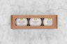 Charcuterie Mini Honey Gift Set with three mini honeys in a brown kraft box with window. From left to right: Portuguese Black Forest Honey, Sourwood Honey, Orange Blossom Honey.