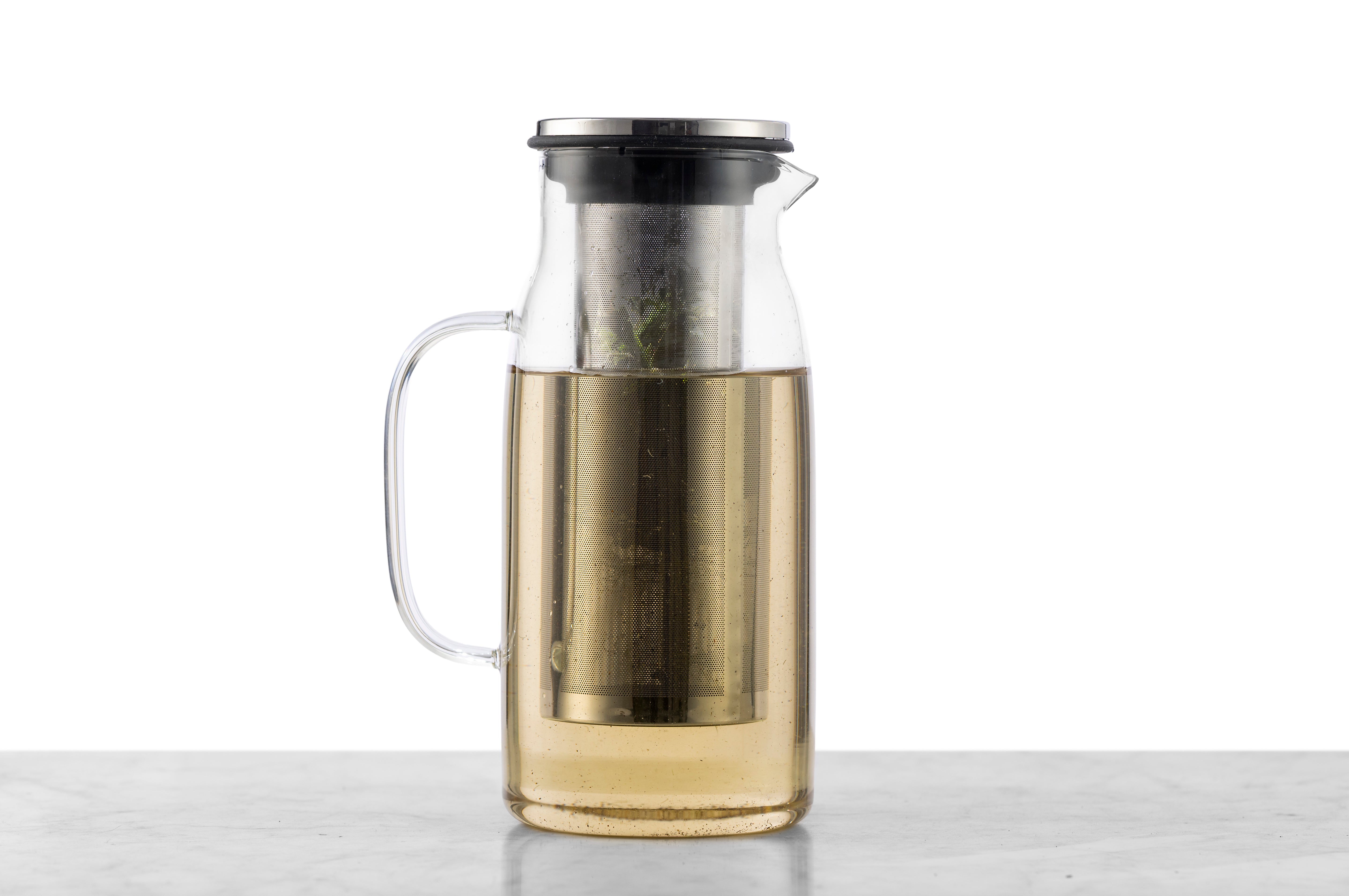 A 1 quart glass iced tea pitcher with a detachable infuser filled with pale yellow tea.