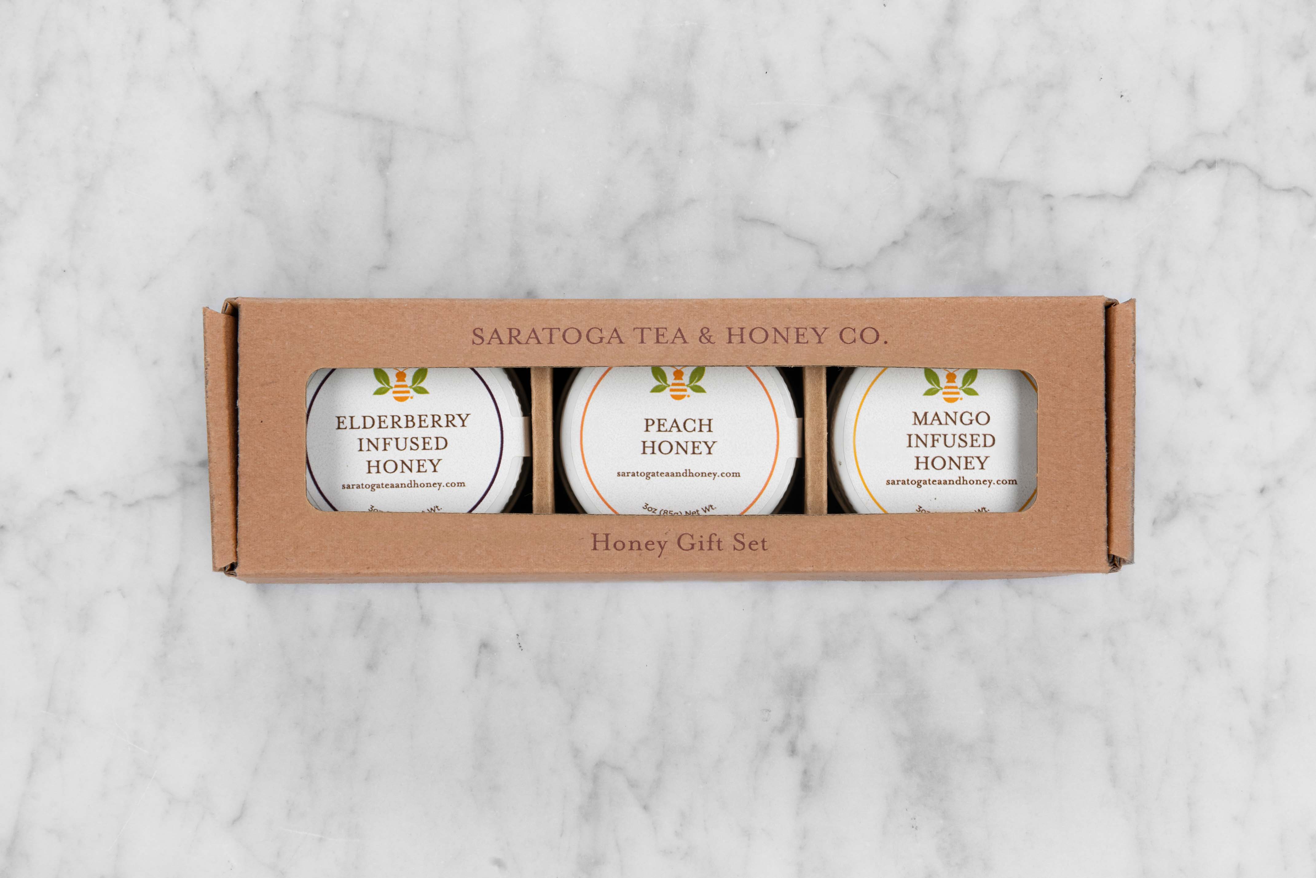 Fruity Honey Gift Set featuring three mini jars of honey: Elderberry Infused Honey, Peach Honey, and Mango Infused Honey.