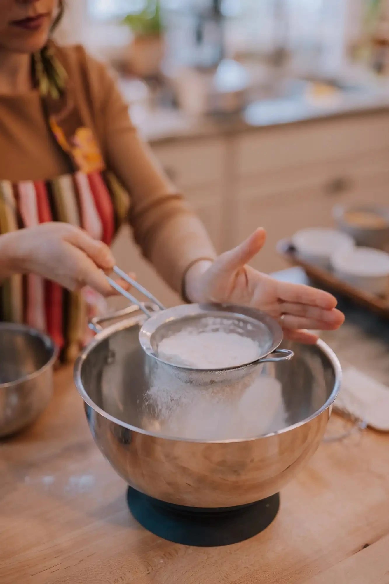 sifting flour into a bowl for an olive oil honey cake