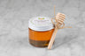3oz jar of Italian Alps Honey with twine and mini dipper on a marble background