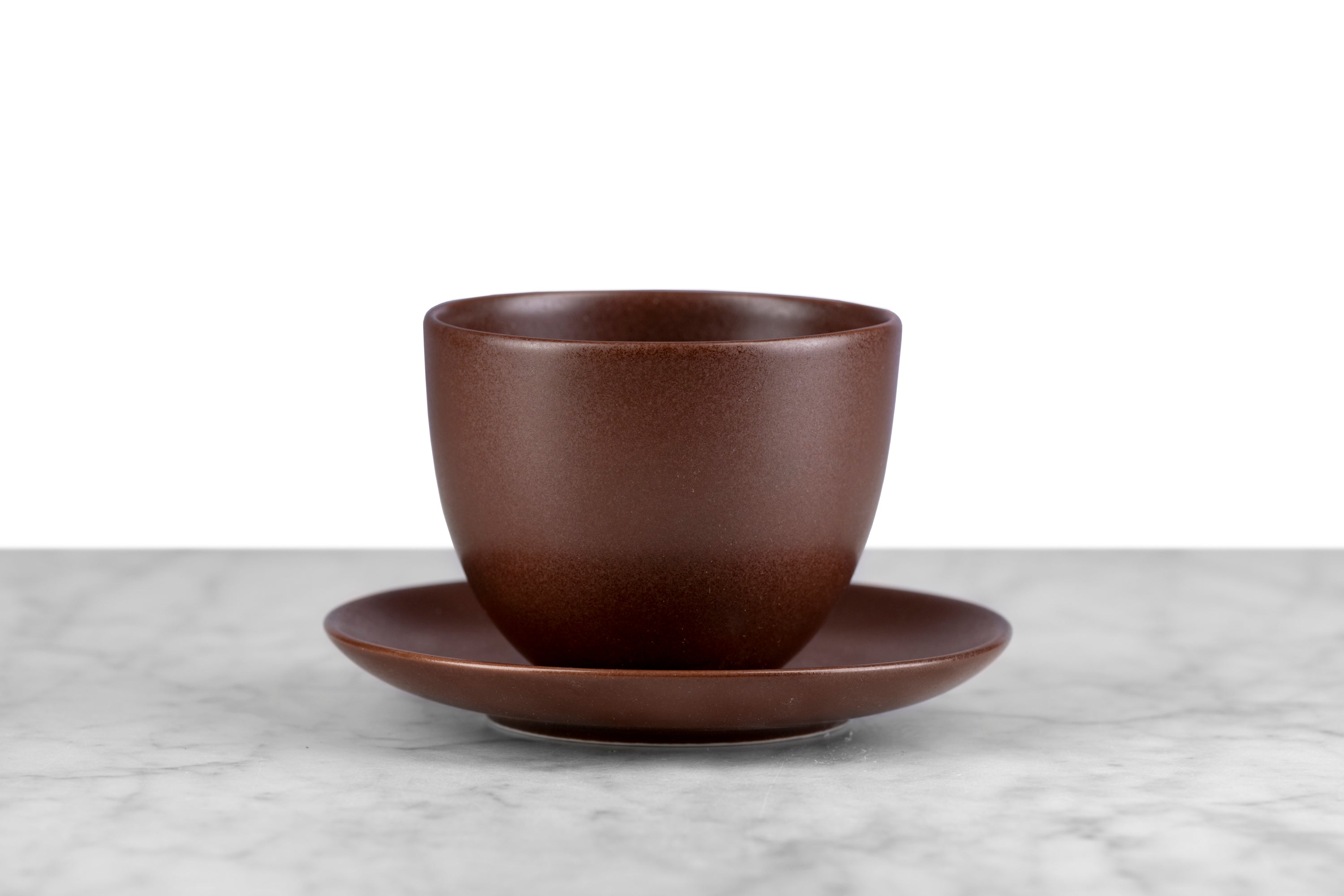 kinto pebble modern Japanese teaware brown handleless cup and saucer on marble with white background