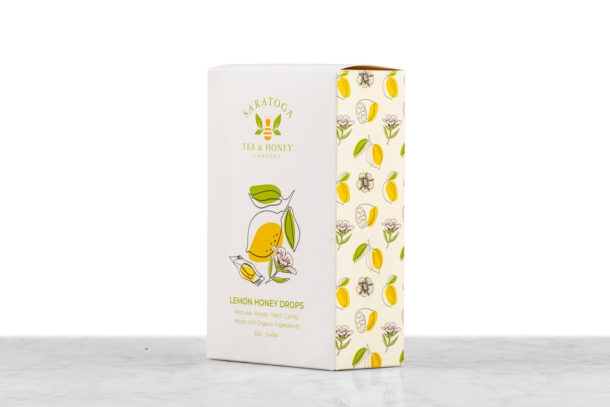 Angled view of Manuka Honey Drops Lemon honey candy box from Saratoga Tea & Honey Co. showing front and side design