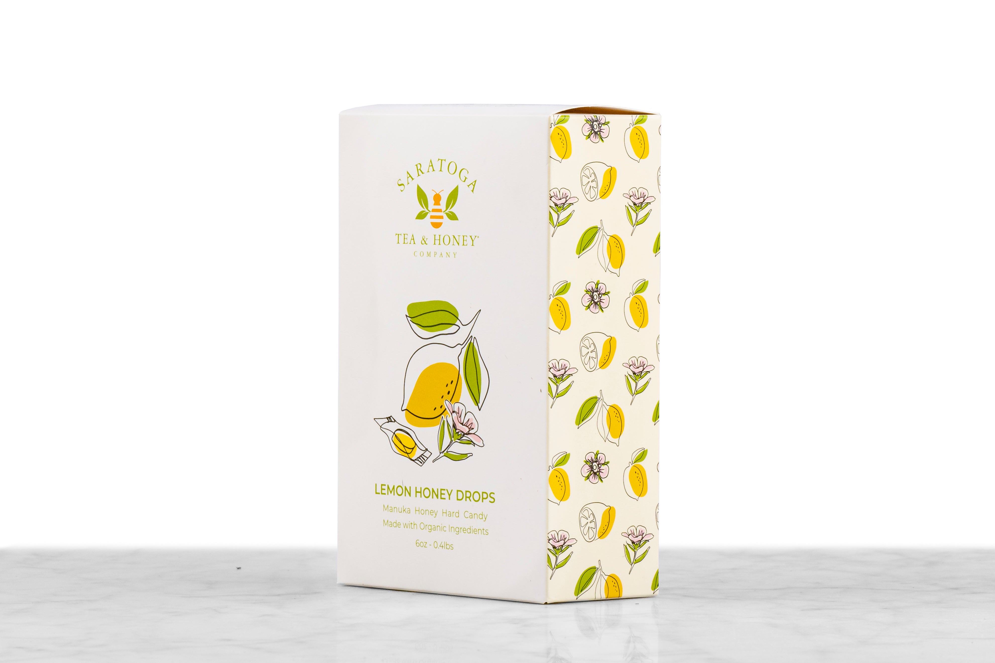 Angled view of Manuka Honey Drops Lemon honey candy box from Saratoga Tea & Honey Co. showing front and side design