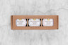 kraft box with an opening showing three mini honey jars of hot honey labeled: Hot Mango Infused Honey, Carolina Reaper Infused Honey, and Ghost Pepper Infused Honey.