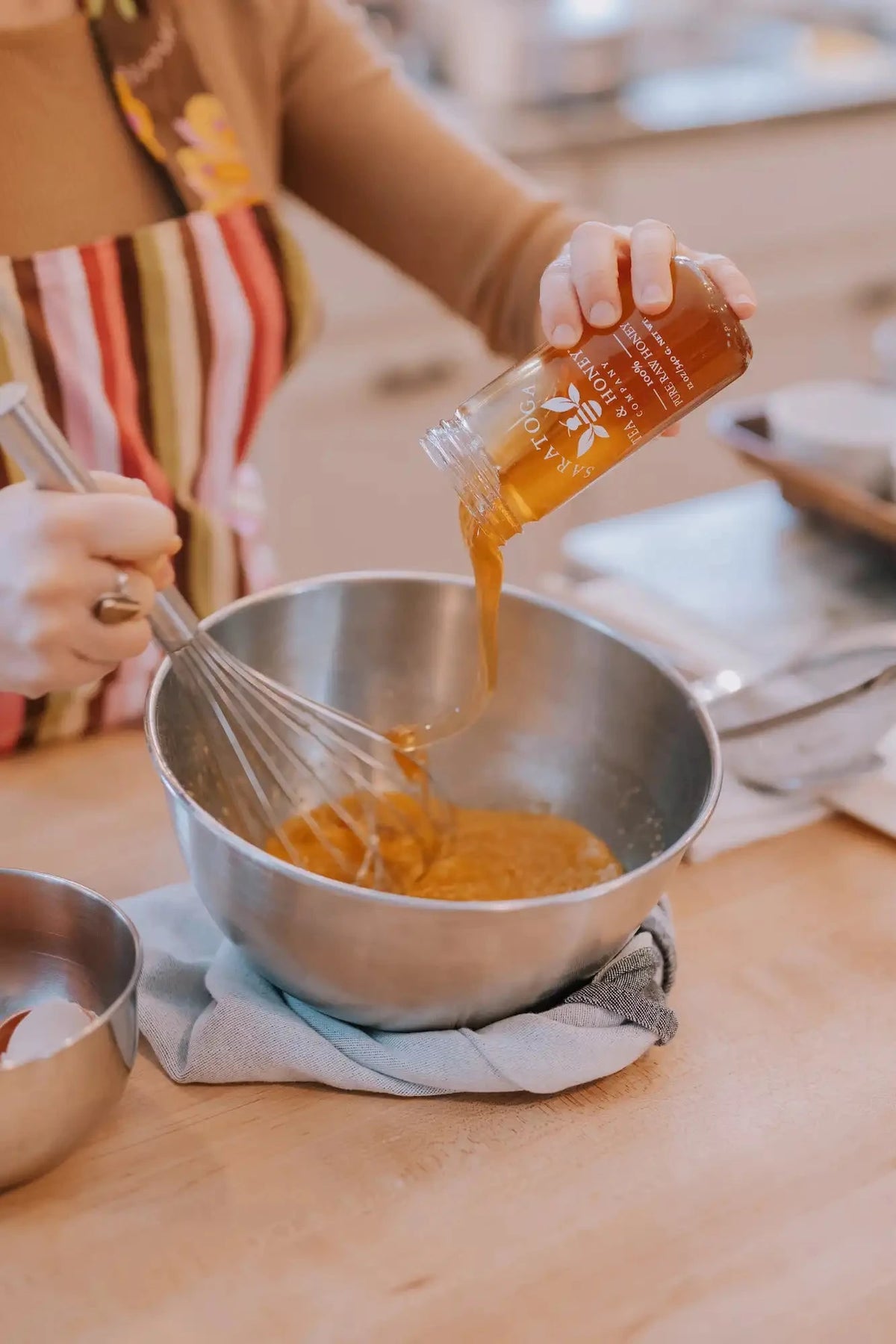 pouring saratoga tea and honey co honey into wet ingredients for honey olive oil cake