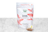 Saratoga Red Chai tea sachet packaging and sample tea sachet. Small, pyramid-shaped tea sachet with visible tea and a bee-logo tag sits next to a pouch reading "Saratoga Red Chai Organic Herbal Tisane. 15 Biodegradable & Compostable Teabags."