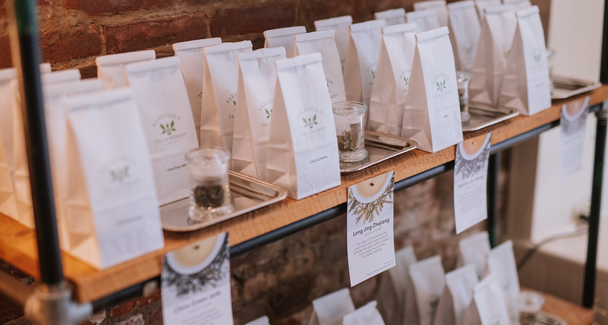 White bags of loose tea on shelves at Saratoga Tea & Honey Co.