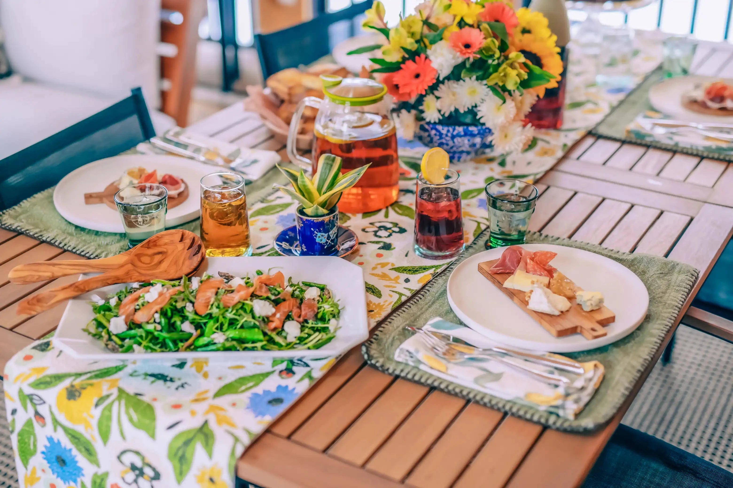 summer lunch party table set with multiple types of iced tea in iced tea pitchers and glasses