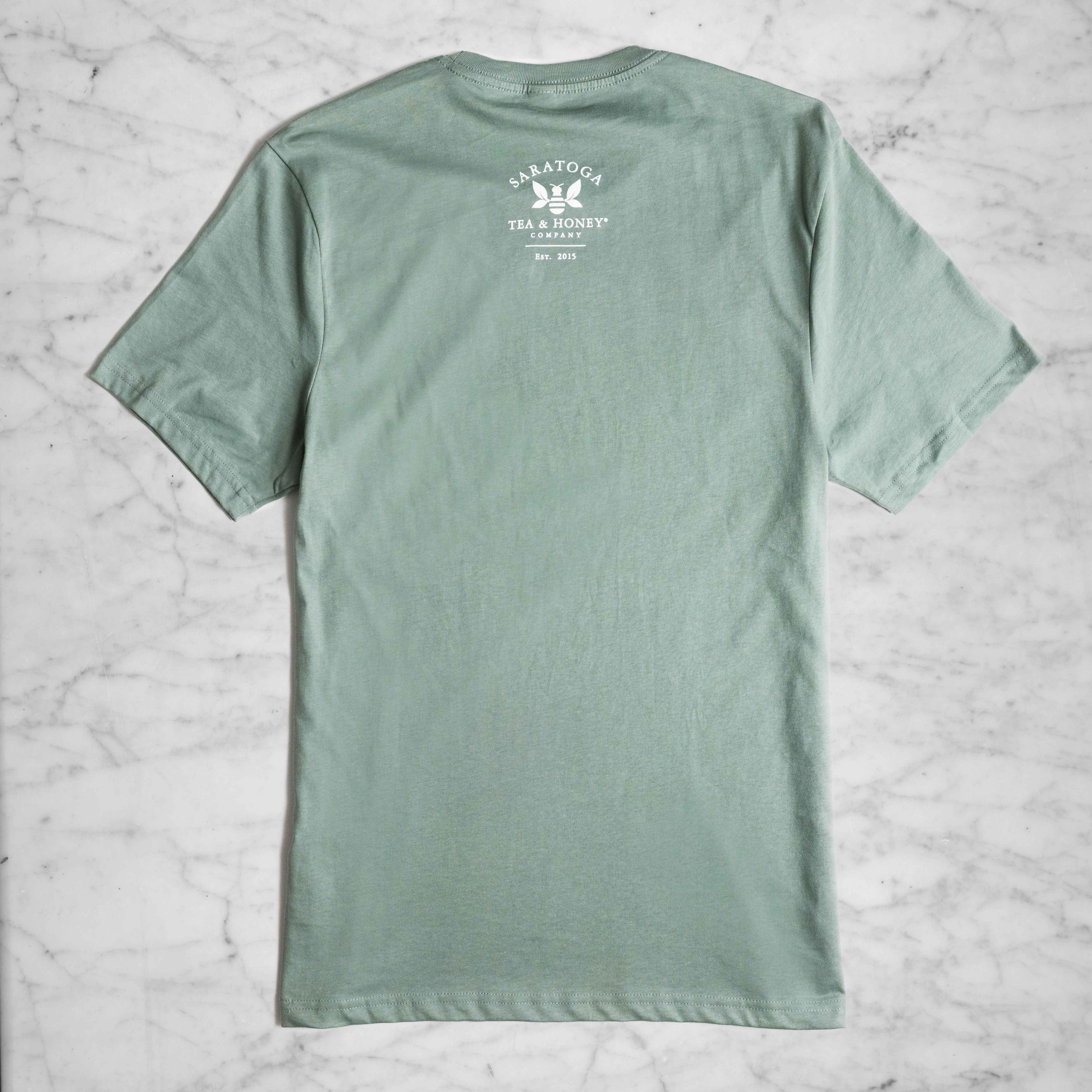 A light sage green short sleeved shirt with the Saratoga Tea and Honey Company logo on the back.