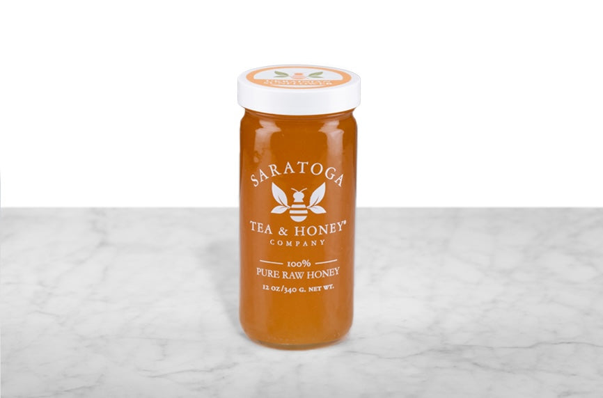 Golden sunflower honey in a 12oz clear glass jar branded with the Saratoga Tea & Honey Co. logo and a white top. The logo and the words: "100% Pure Raw Honey" are printed on the jar.