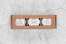 kraft box with an opening showing three mini honey jars of local Upstate NY honeys: Columbia County Wildflower, Saratoga Springs Wildflower Honey, and Sumac and Clover Honey