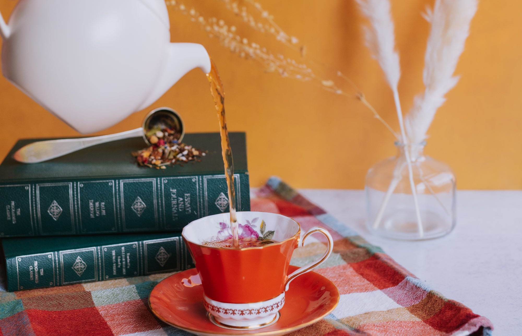 pouring herbal tisane into a vintage teacup