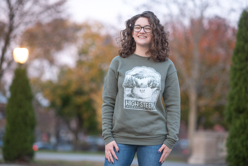 woman wearing vintage high steeps olive green sweatshirt with tea pun