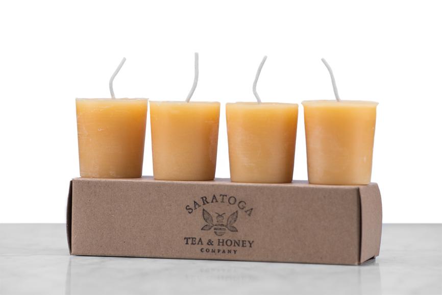 4 beeswax votive candles sitting on a kraft box