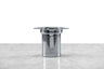 side view of a stainless steel tea infuser sitting on a marble and white background