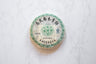 2007 Yiwu Jing Long sheng pu'er round aged tea cake wrapped in paper with Chinese characters.