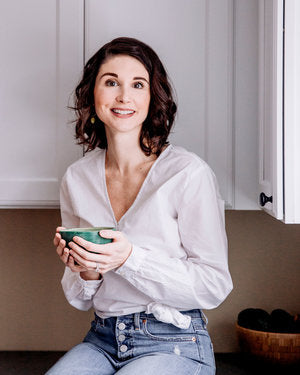 herbalist barb biagioli sitting in her kitchen with a mug
